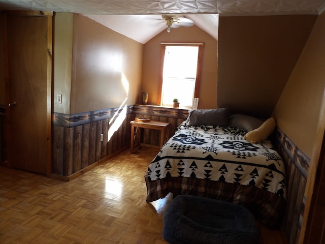 bedroom with ceiling fan, light parquet flooring, and vaulted ceiling