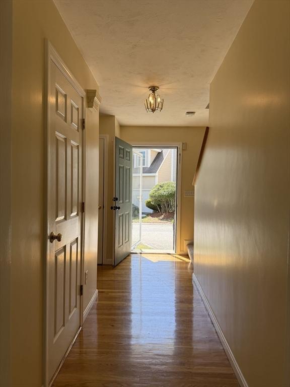 5 Samantha Way Unit 5, Acton, MA 01720 - hallway with dark wood finished floors, baseboards, and a chandelier