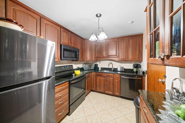 kitchen featuring sink, stainless steel appliances, a notable chandelier, dark stone counters, and light tile patterned flooring