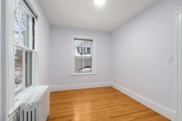 empty room with light hardwood / wood-style floors and radiator