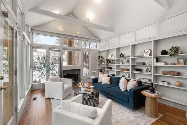 interior space with a tiled fireplace and lofted ceiling