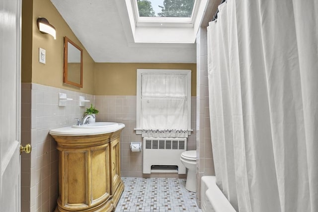 23 Ivan St, Lexington, MA 02420 - bathroom with radiator, a skylight, tile walls, vanity, and shower / bath combo with shower curtain