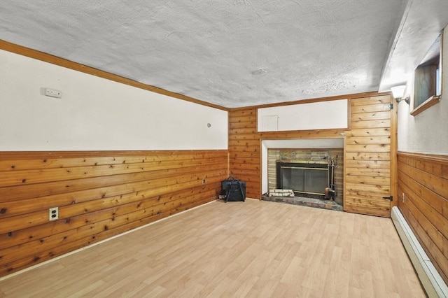 23 Ivan St, Lexington, MA 02420 - unfurnished living room featuring baseboard heating, wood walls, wood finished floors, a textured ceiling, and a brick fireplace