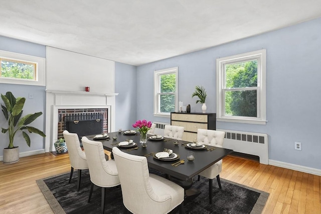 23 Ivan St, Lexington, MA 02420 - dining room with radiator, wood finished floors, and a brick fireplace