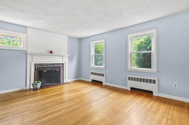 23 Ivan St, Lexington, MA 02420 - unfurnished living room with radiator, hardwood / wood-style flooring, and a fireplace with flush hearth