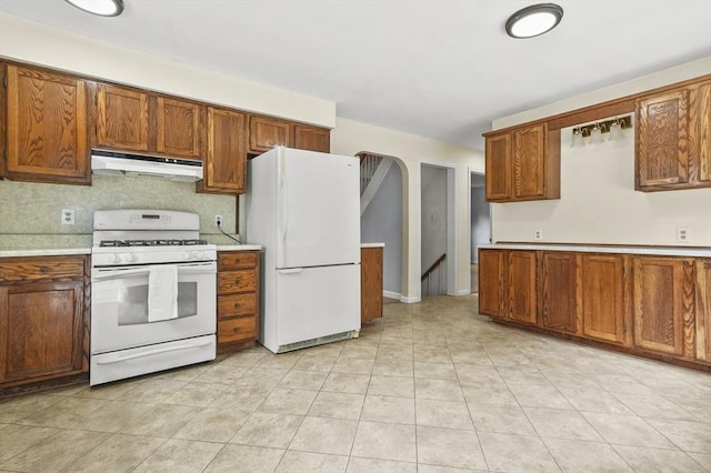 23 Ivan St, Lexington, MA 02420 - kitchen featuring white appliances, under cabinet range hood, light countertops, and brown cabinetry