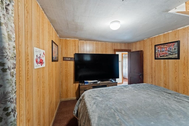 carpeted bedroom featuring wood walls