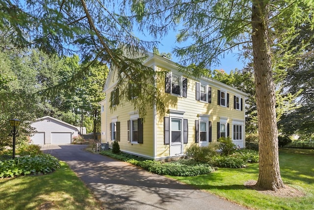 colonial home with an outbuilding, a front yard, and a garage