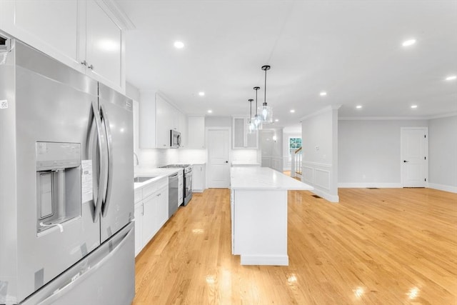 kitchen featuring appliances with stainless steel finishes, a center island, and white cabinetry