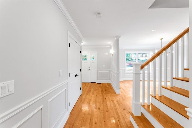 interior space with light wood-type flooring and crown molding