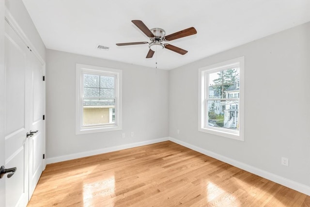 unfurnished room with light hardwood / wood-style flooring, plenty of natural light, and ceiling fan