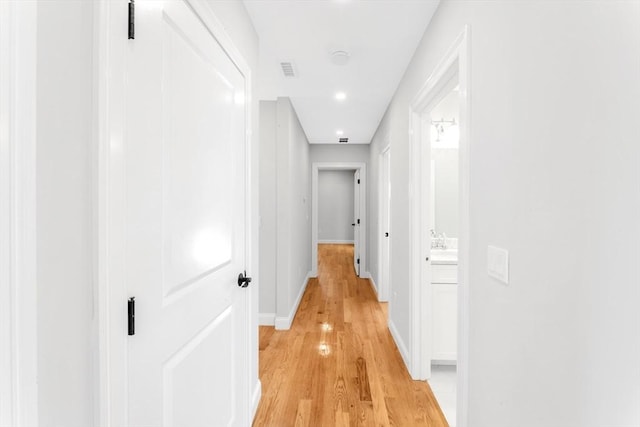 corridor with light hardwood / wood-style floors