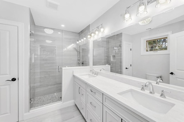 bathroom featuring toilet, an enclosed shower, and vanity