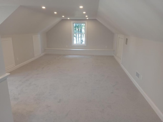 bonus room featuring light carpet and vaulted ceiling