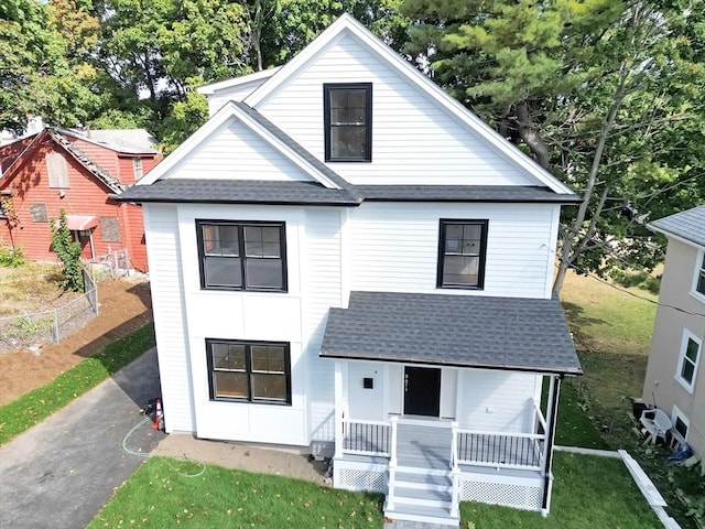 view of front of property with covered porch and a front lawn