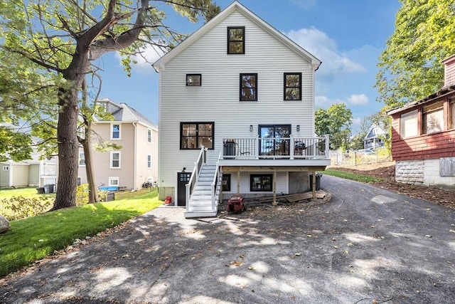 rear view of house with a yard, a deck, and central air condition unit