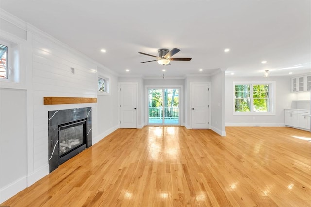 unfurnished living room featuring ceiling fan, ornamental molding, and light hardwood / wood-style flooring