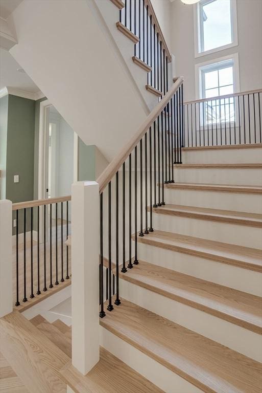 stairs with a high ceiling and wood finished floors