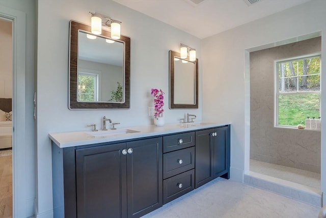 full bath with double vanity, walk in shower, and a sink