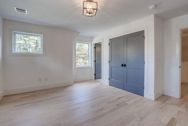 unfurnished bedroom with a closet, visible vents, light wood-style flooring, and baseboards