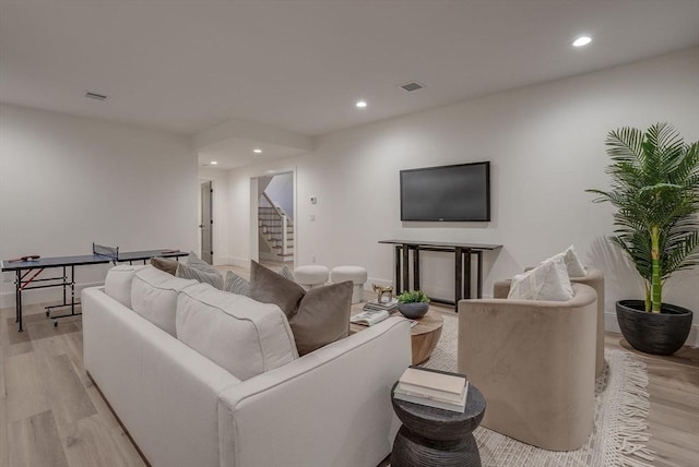 living area with light wood finished floors, stairway, and recessed lighting