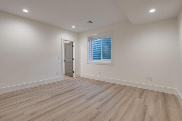 spare room featuring light wood-style floors, recessed lighting, visible vents, and baseboards