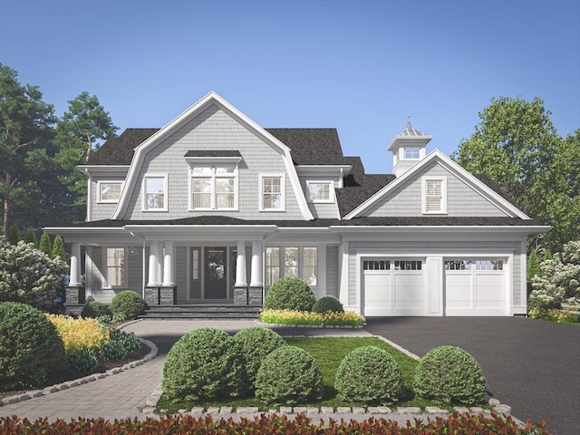 view of front of home featuring aphalt driveway, an attached garage, and a gambrel roof