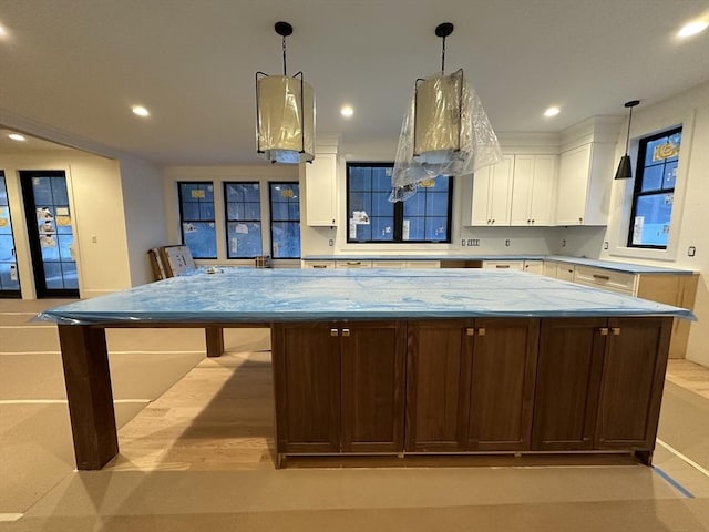 kitchen with light stone counters, decorative light fixtures, a large island, recessed lighting, and white cabinetry