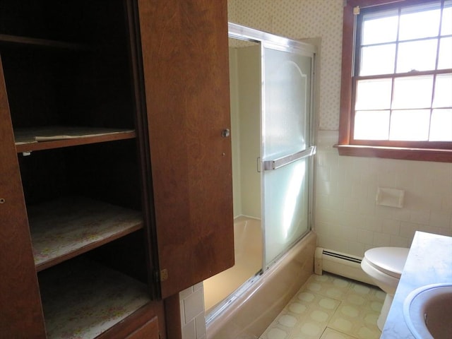 bathroom with toilet, shower / bath combination with glass door, wallpapered walls, baseboard heating, and vanity