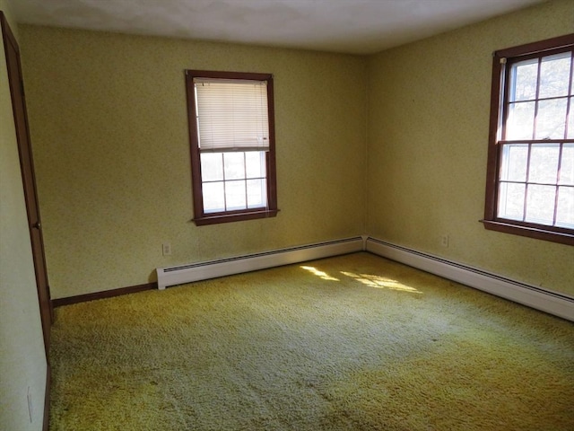 carpeted spare room with a wealth of natural light and baseboard heating