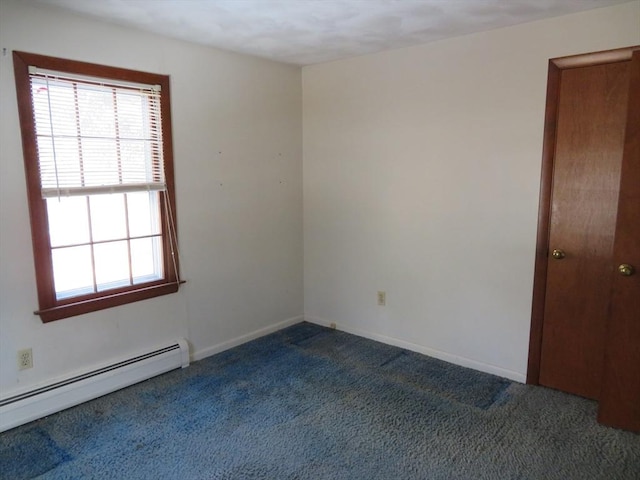 empty room with baseboards, dark colored carpet, and a baseboard radiator