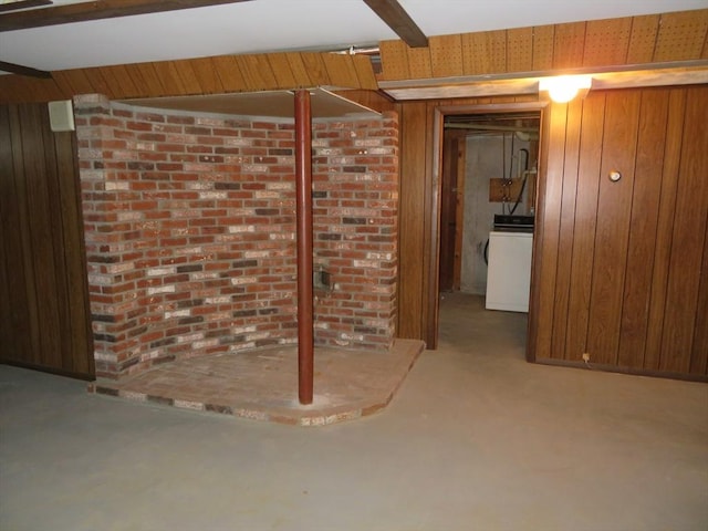 finished below grade area featuring washer / dryer and wood walls