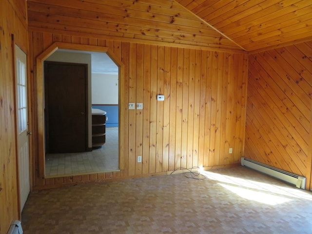 unfurnished room with baseboard heating, wood walls, and vaulted ceiling