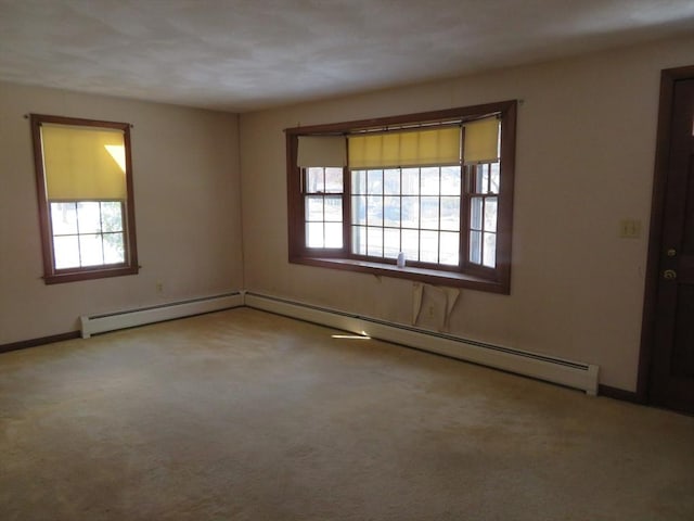 empty room featuring baseboard heating, baseboards, and carpet floors