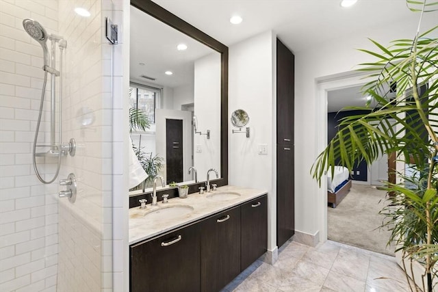 full bath featuring recessed lighting, tiled shower, a sink, and double vanity