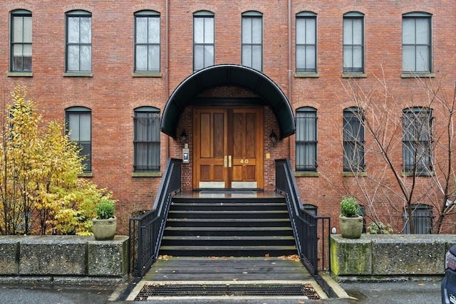 doorway to property featuring brick siding