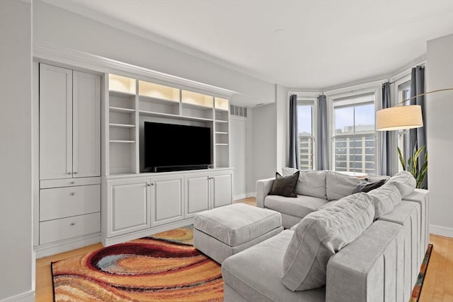 living room with light wood-type flooring, visible vents, and baseboards