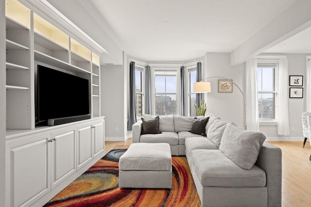 living area with light wood-style floors and baseboards