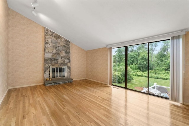 18 Juniper Ln, Framingham, MA 01701 - unfurnished living room with wood finished floors, a fireplace, and vaulted ceiling