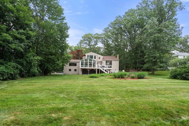 18 Juniper Ln, Framingham, MA 01701 - back of property featuring a sunroom, stairs, a lawn, and a chimney