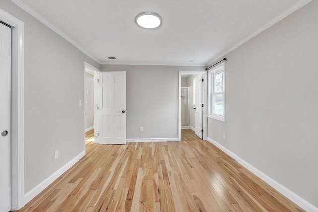 unfurnished bedroom featuring ornamental molding and light hardwood / wood-style floors