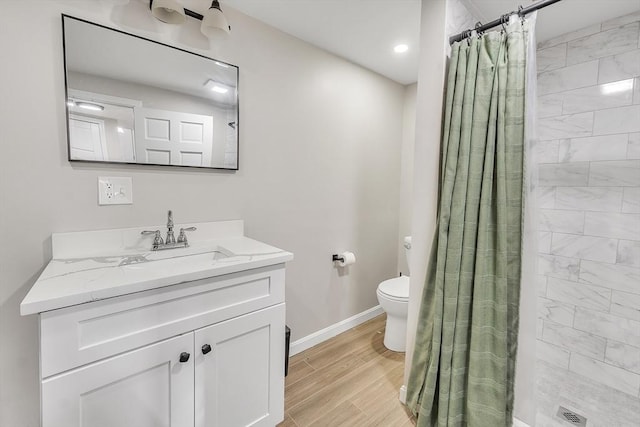 bathroom featuring vanity, toilet, hardwood / wood-style floors, and walk in shower