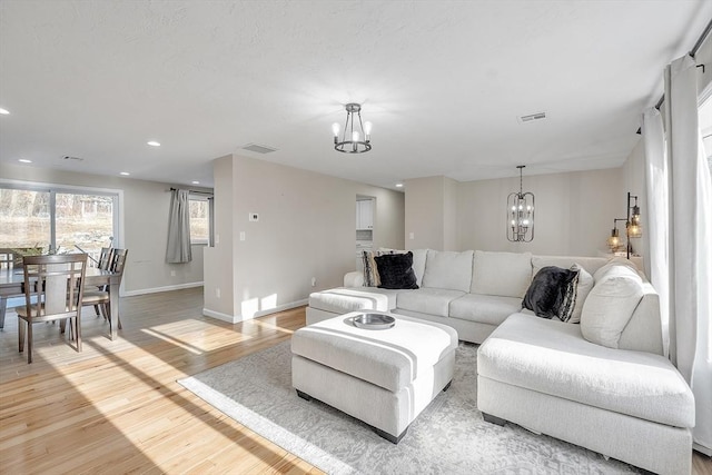 living room featuring a notable chandelier and light hardwood / wood-style floors