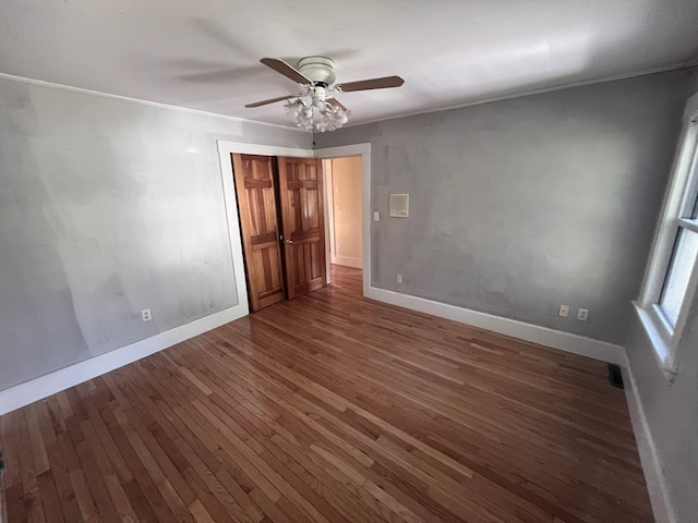 unfurnished bedroom featuring crown molding, dark hardwood / wood-style flooring, and ceiling fan