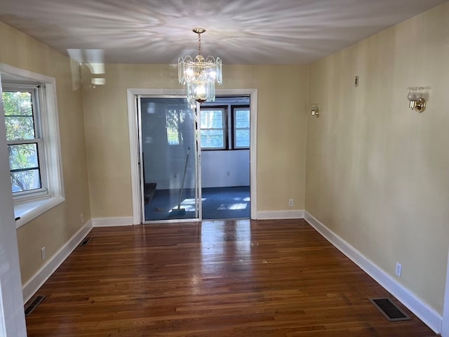 unfurnished dining area with a chandelier and dark wood-type flooring