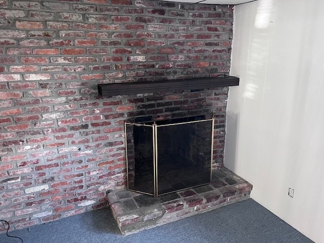 room details featuring carpet floors and a brick fireplace