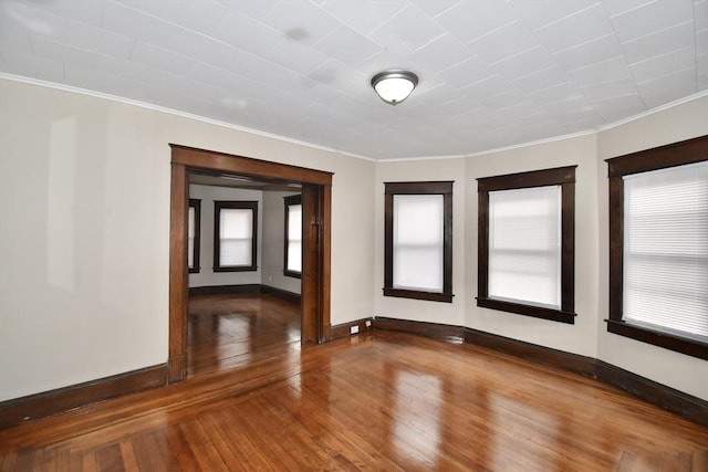 empty room featuring hardwood / wood-style flooring and ornamental molding