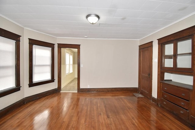 empty room featuring dark hardwood / wood-style flooring and ornamental molding