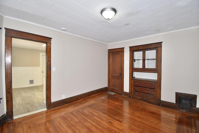 interior space featuring hardwood / wood-style flooring and ornamental molding