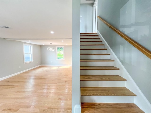 stairway featuring recessed lighting, visible vents, baseboards, and wood finished floors